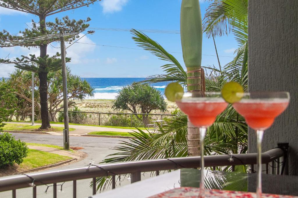 黄金海岸Bilinga Bliss - Luxury beachfront apartment的一张桌子和两杯,享有海滩美景
