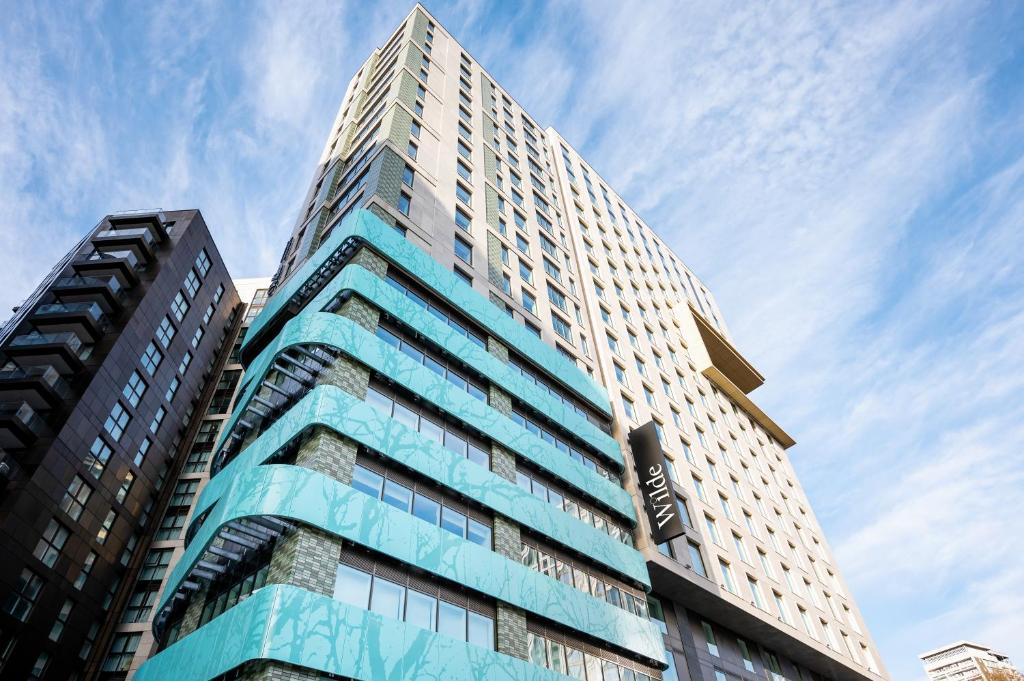 伦敦Wilde Aparthotels London Paddington的一座高大的建筑,背后是蓝天