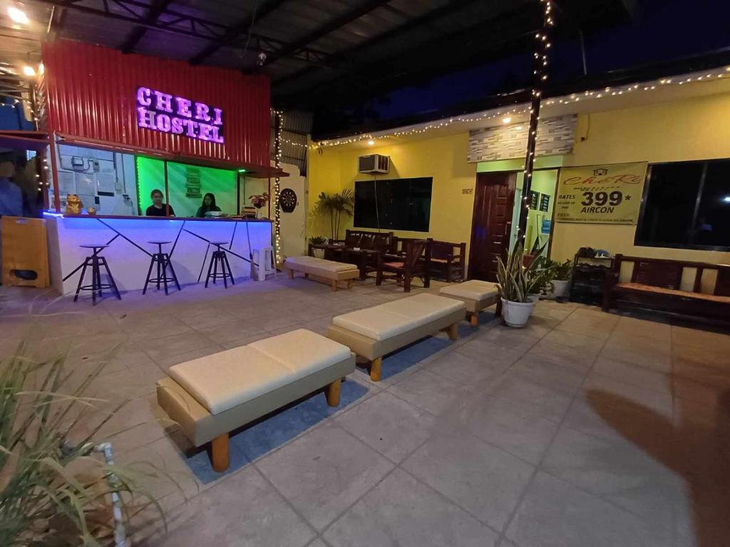 莫阿尔博阿CheRi Backpackers Hostel的一间带长椅的房间和一间带舞台的酒吧