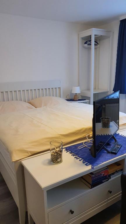 黑尔戈兰岛艾尔葛洛斯提贝公寓的一间卧室配有一张床和一张桌子,上面配有电脑