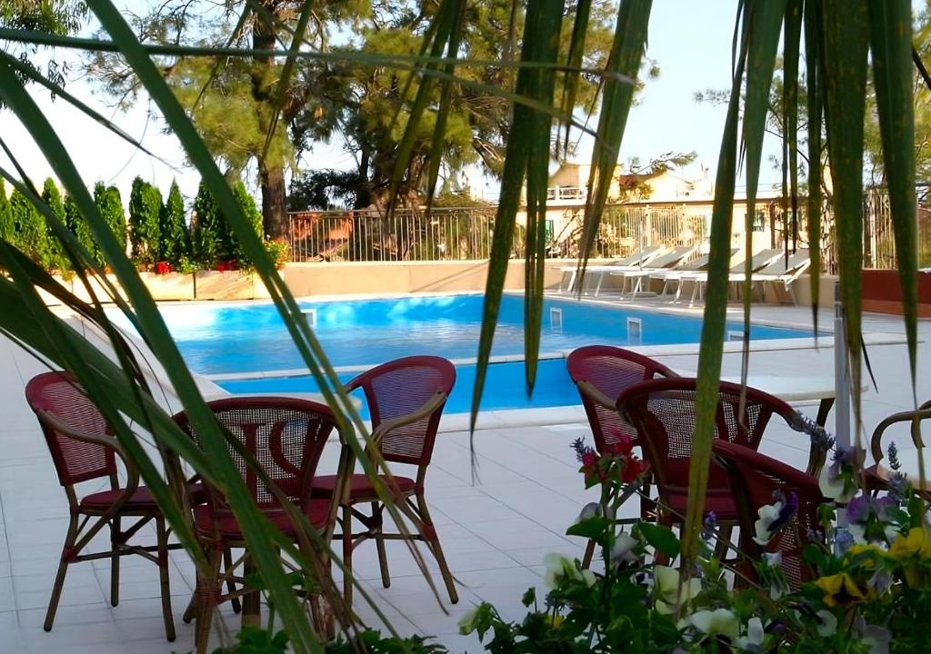 菲纳莱利古雷圣朱塞佩酒店的一组椅子坐在游泳池旁
