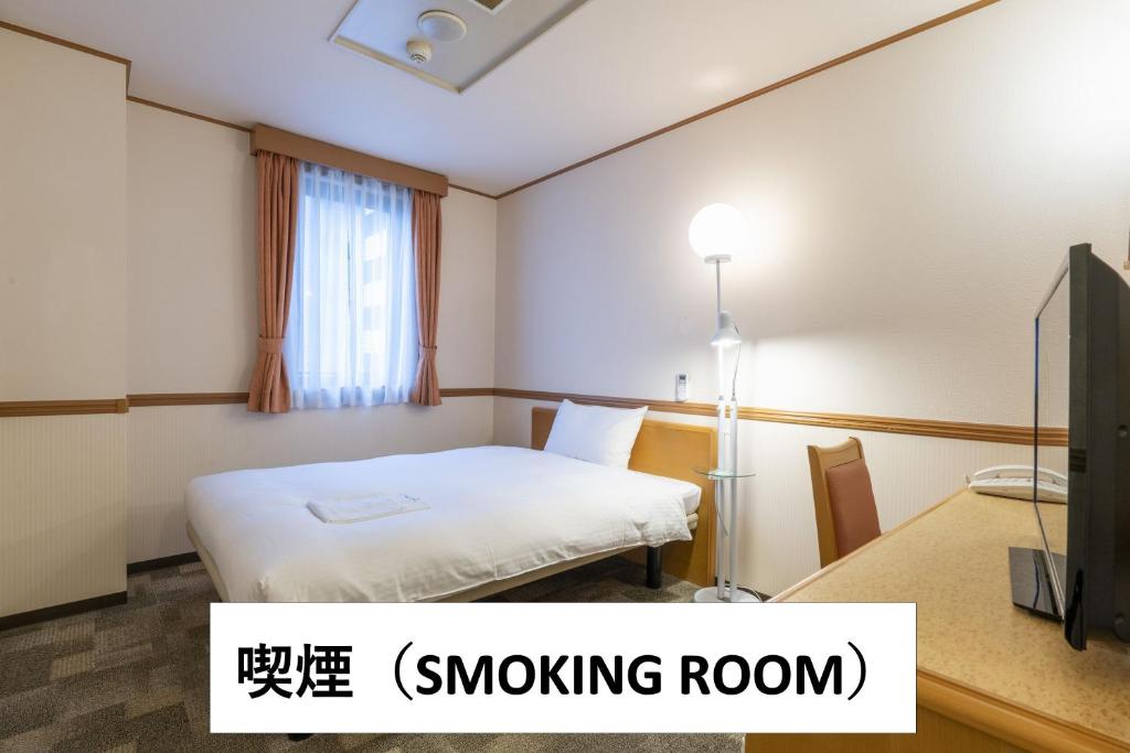 岐阜Hotel Endear Gifu的一间酒店客房,配有一张床和一台电视