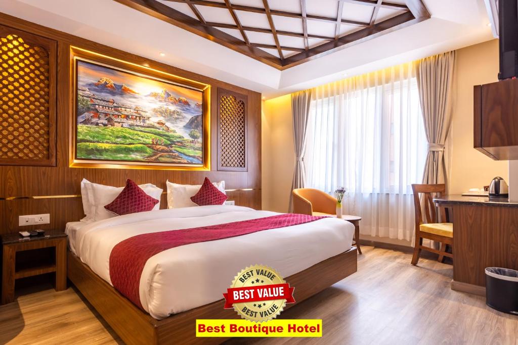 加德满都Kailash Boutique Hotel的配有一张床和一张书桌的酒店客房