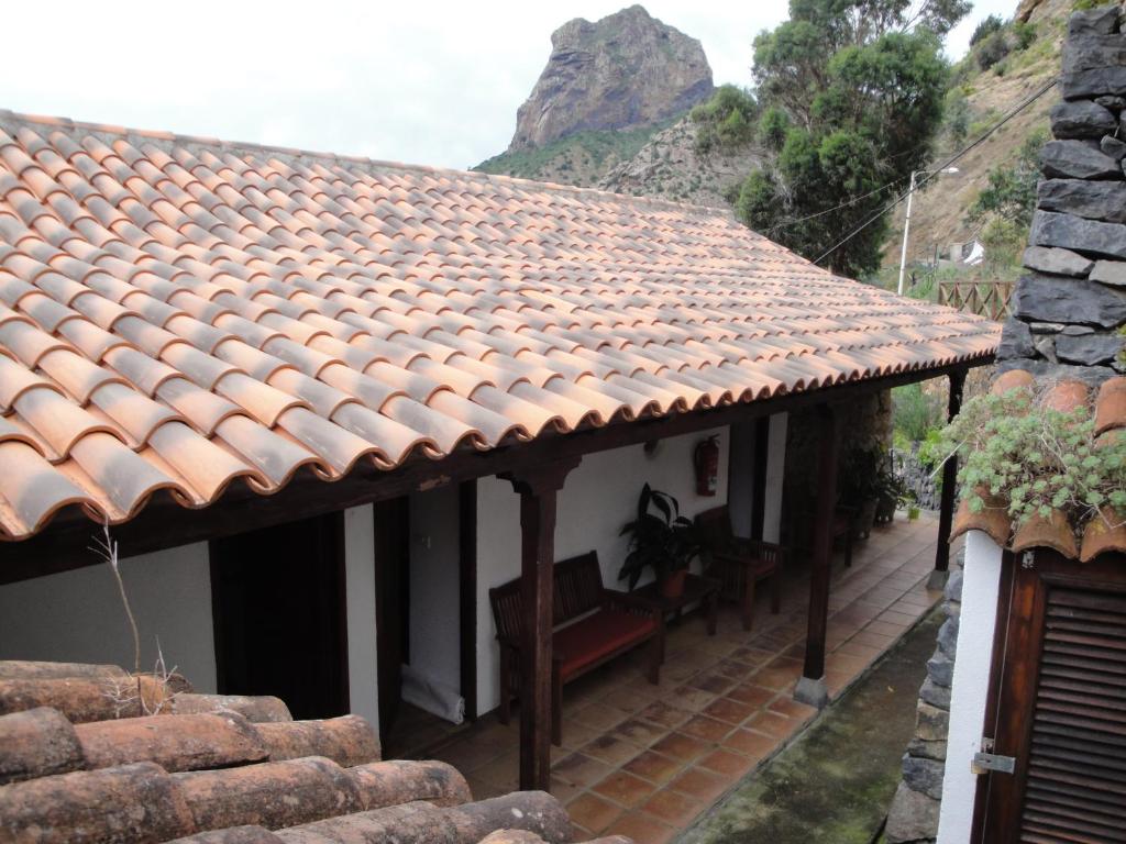 巴列埃尔莫索Casa Rural Guaidil的白色的房子,设有瓷砖屋顶和长凳