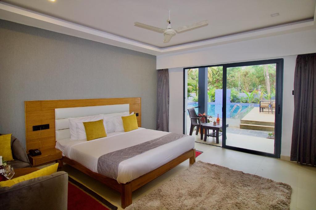莫尔吉姆FabHotel Resort De Ashvem的一间卧室设有一张床和一间客厅。