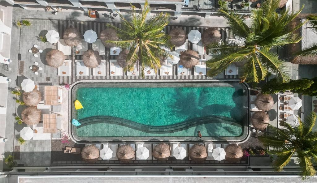 龙目岛库塔El Tropico Boutique Hotel的享有棕榈树游泳池的顶部景致
