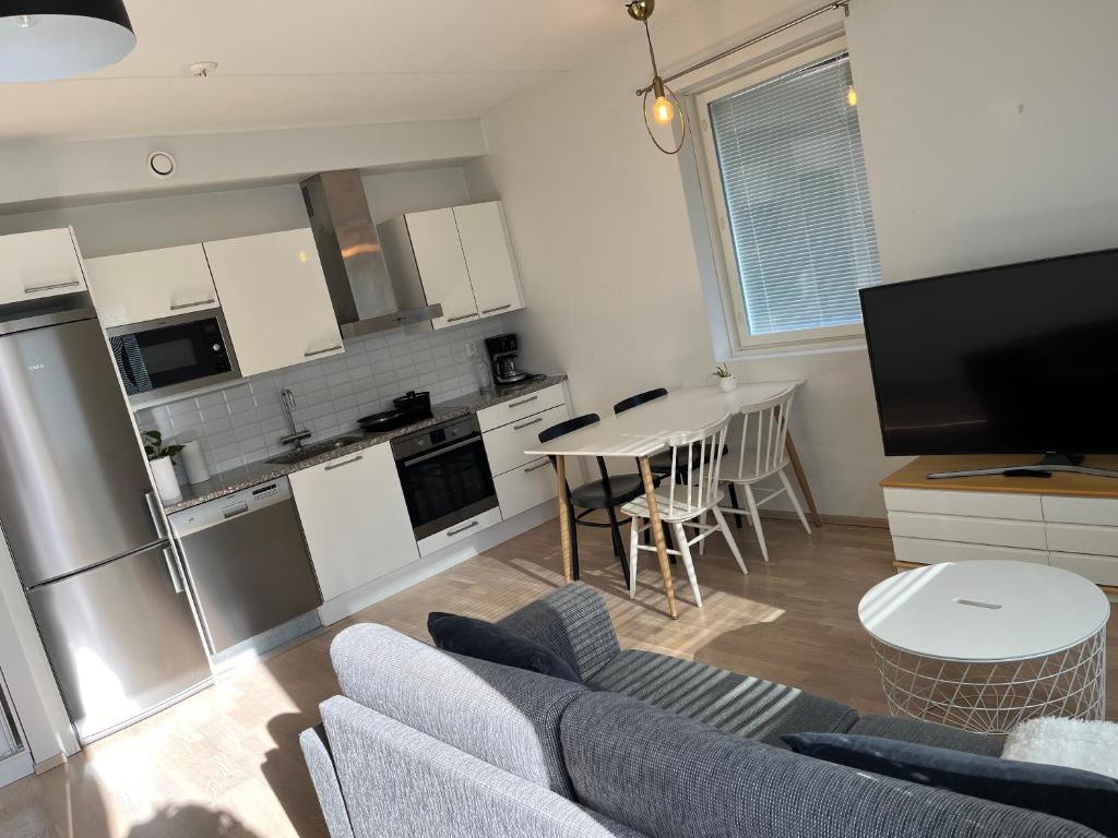 波尔沃Riverside cozy flat in Porvoo的厨房以及带沙发和桌子的客厅。