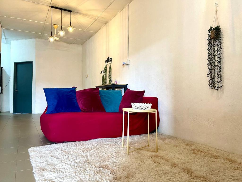大山脚Cozy33#4pax#Wifi#NearAeonAlma#20minstobatukawan的客厅配有红色的沙发和桌子
