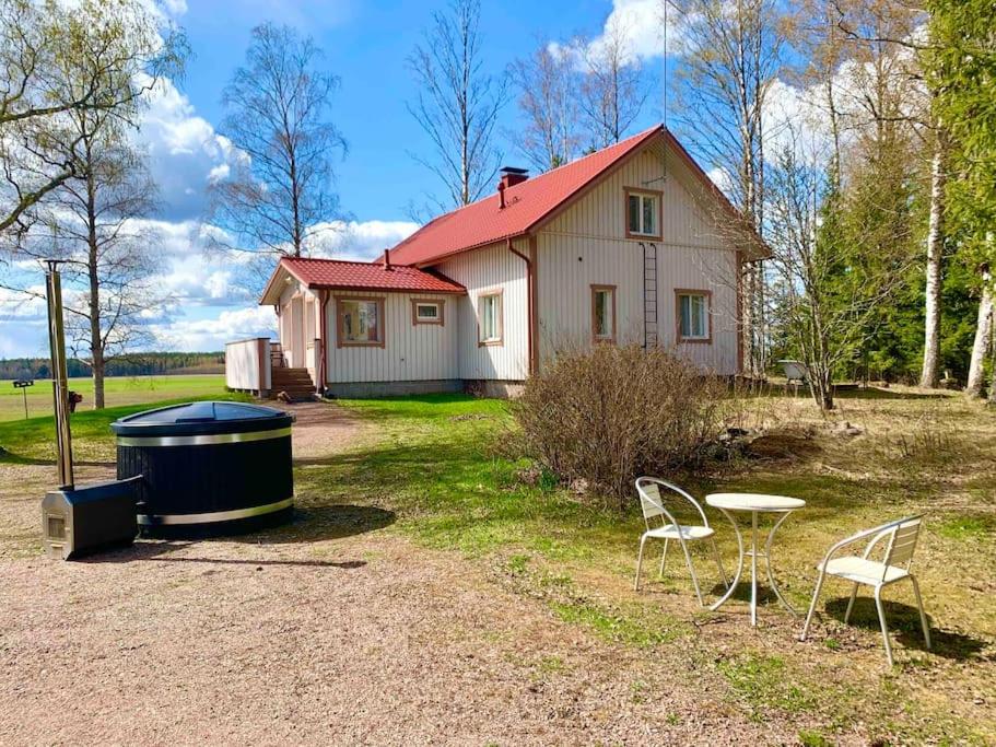 拉平耶尔维Villa Ullakko - vuokramummola, ihana talo maalla的房屋设有浴缸、两把椅子和一张桌子