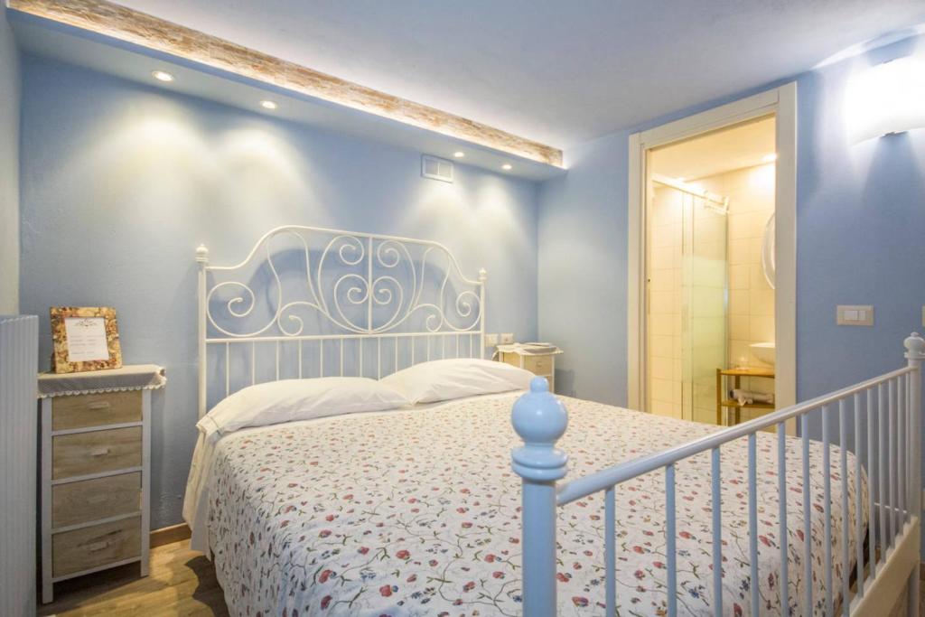 Casnate con Bernate拉孔特拉达住宿加早餐旅馆的卧室配有白色的床和蓝色的墙壁