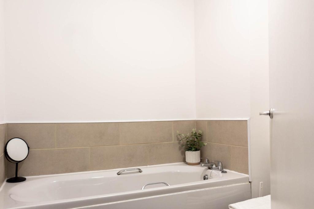 利文-法夫Dubbie House的浴室设有白色浴缸及镜子