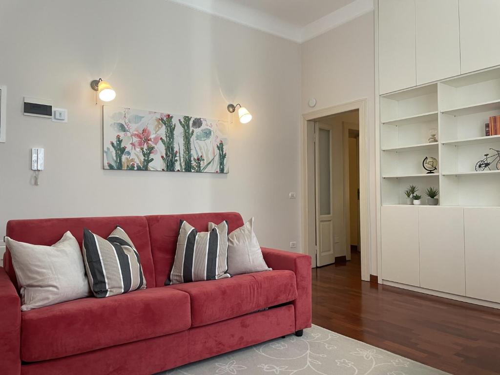 米兰Umbria 60 Apartment的客厅里配有红色沙发及枕头
