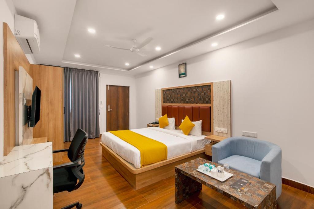 班加罗尔Gateway Premium Inn的配有一张床和一把椅子的酒店客房
