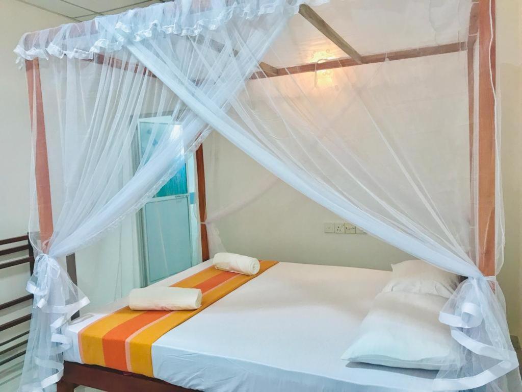 蒂瑟默哈拉默Tashil Hotel & Restaurant的一间卧室配有一张带毛巾的天蓬床。