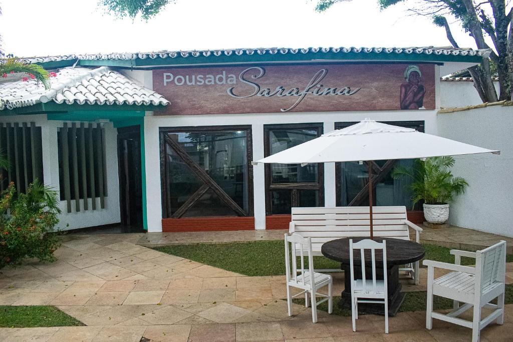萨尔瓦多pousada da sarafina ltda的餐厅前的桌子、椅子和遮阳伞
