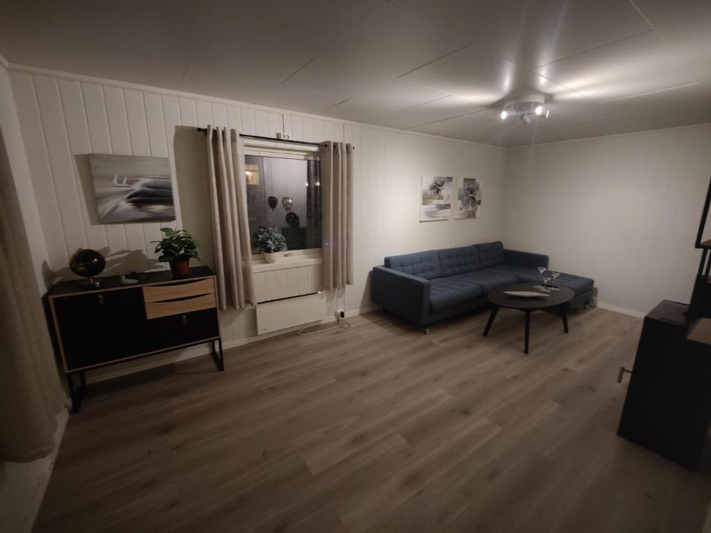 瓦尔德Vardø accommodation - white house的客厅配有蓝色的沙发和桌子