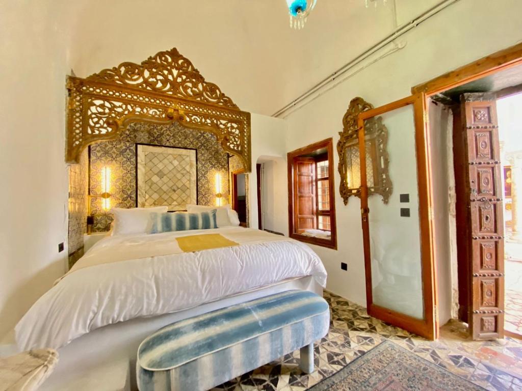 西迪·布·赛义德Suite Noor B&B Pool SidiBouSaid的一间卧室配有一张大床和木制床头板