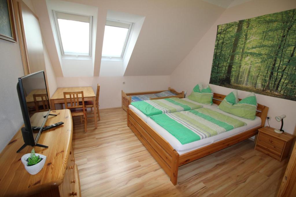 OttenschlagPrivatzimmer Fam. Führer的一间卧室配有一张带绿色枕头的床和一张书桌