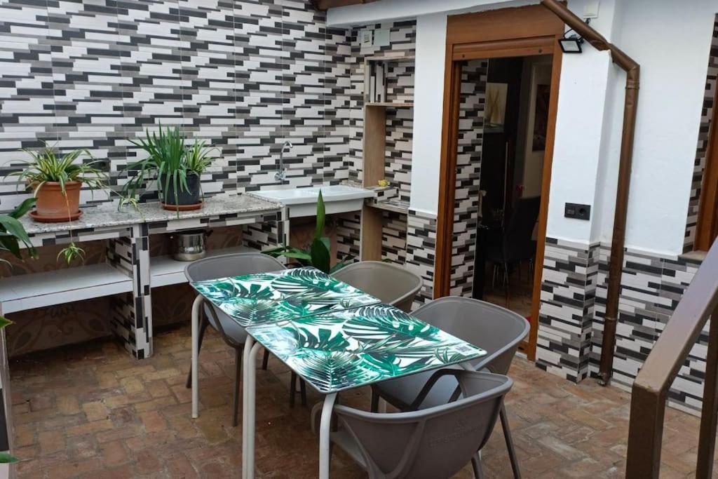 格拉纳达Casa preciosa con vistas的庭院配有桌椅和植物