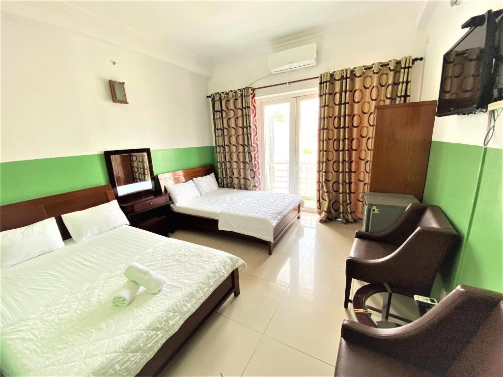 胡志明市Khách sạn Anh Thư的一间设有两张床和椅子的房间