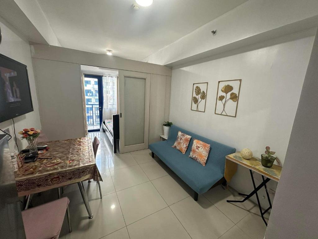 马尼拉Sea Residences MOA Complex - Ruffa's Condotel的客厅配有蓝色的沙发和桌子