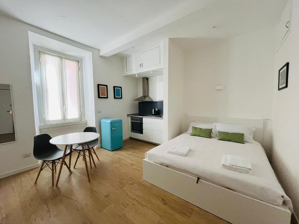米兰Lomat Apartment的白色卧室配有床和桌子