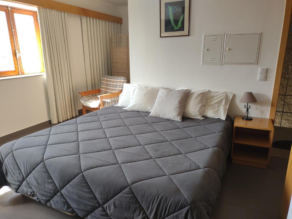 维亚纳堡Valentim House的一间卧室配有一张带灰色毯子的大床