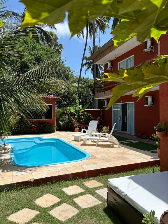 嘎林海斯港Pousada Recanto Pontal de Maracaipe的房屋前的游泳池