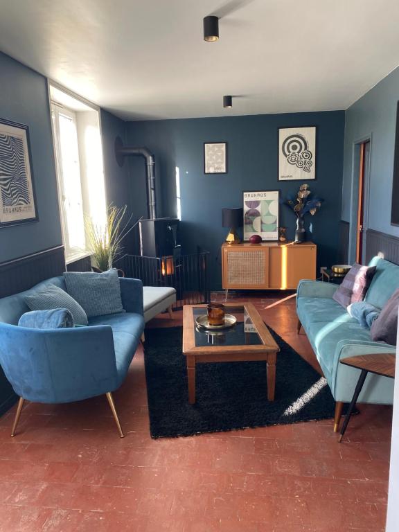 Monceaux-en-BessinMaison au cœur d'une ancienne ferme à BAYEUX的客厅配有2张蓝色的沙发和1张桌子