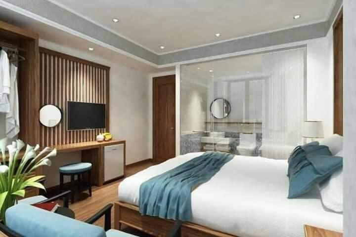 宁平Tam Coc Condelux Boutique Hotel & Travel的一间大卧室,配有一张大床和一台电视