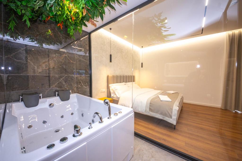 地拉那Hotel Riviera的一间带浴缸的浴室和一张位于客房内的床