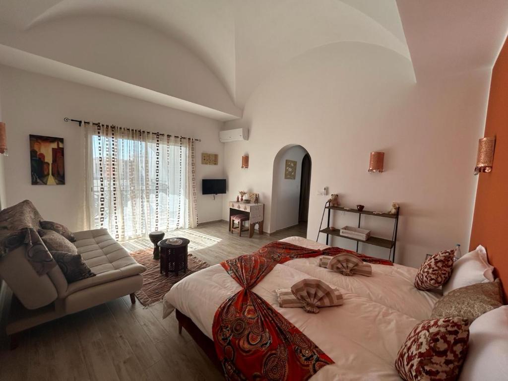 迈来亚Dar El Kahina Djerba的一间带大床的卧室和一间客厅