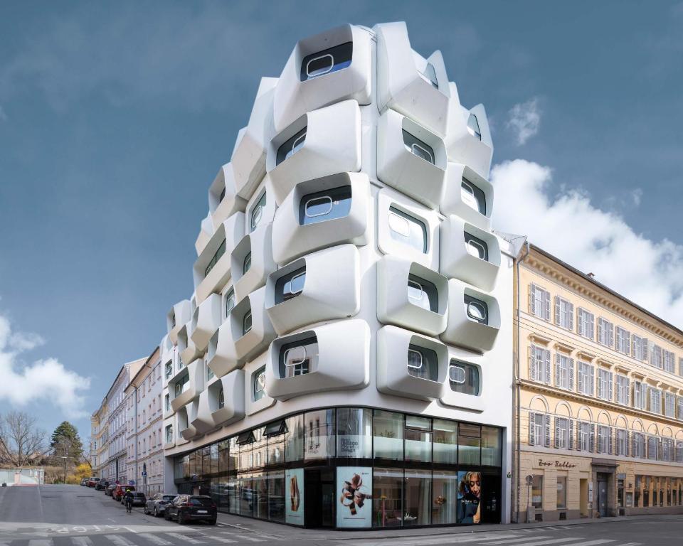 格拉茨limehome Graz - Argos by Zaha Hadid的街道边的白色建筑,设有窗户