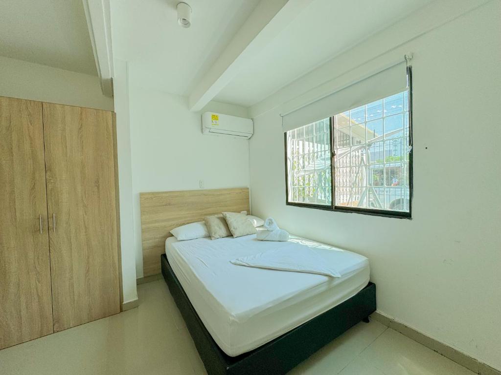 圣玛尔塔Hotel Tamara House的一间小卧室,配有一张带窗户的床