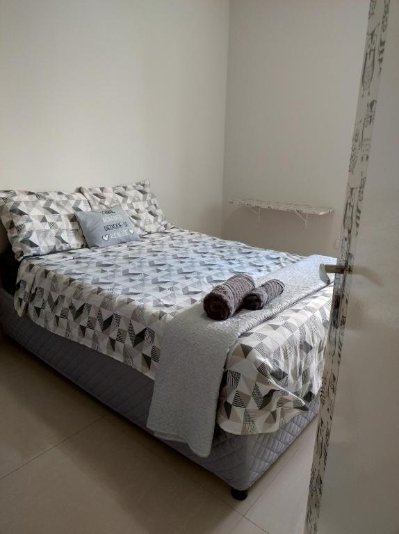 库亚巴Quarto em apartamento em Cuiabá的客房内的一张带拖鞋的床