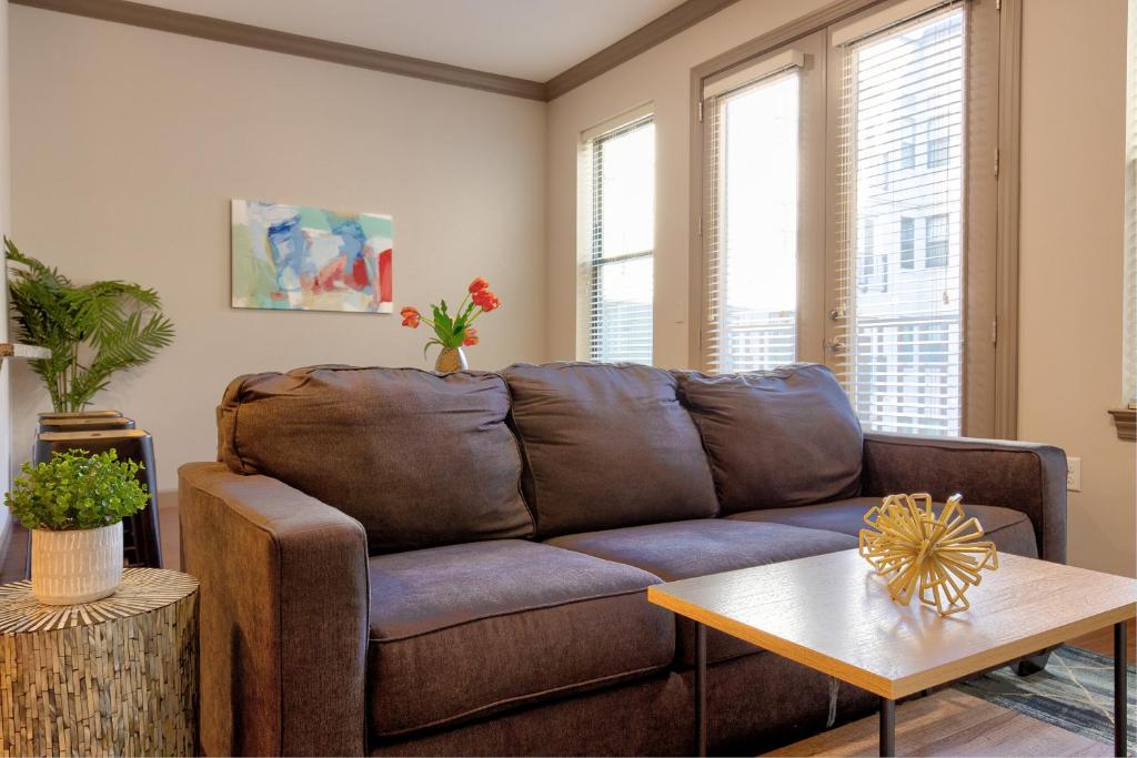 马里兰高地Kasa Central West End St Louis的客厅配有棕色沙发和桌子