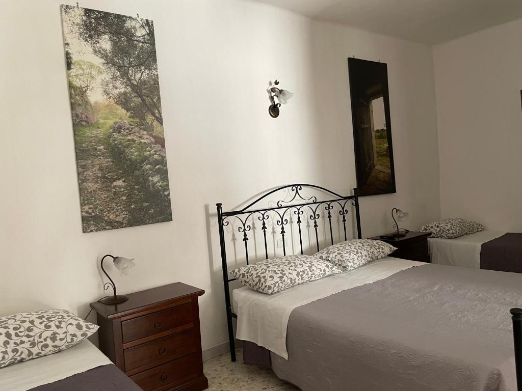 普蒂尼亚诺Arco Michele的一间卧室配有两张床和镜子