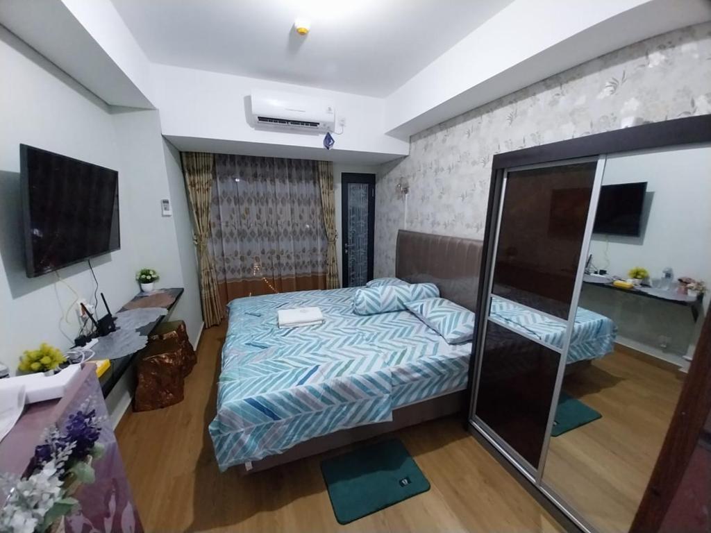 巴淡岛中心Sri Studio 07@Pollux Habibie Meisterstadt的一间卧室配有一张床和一台电视。
