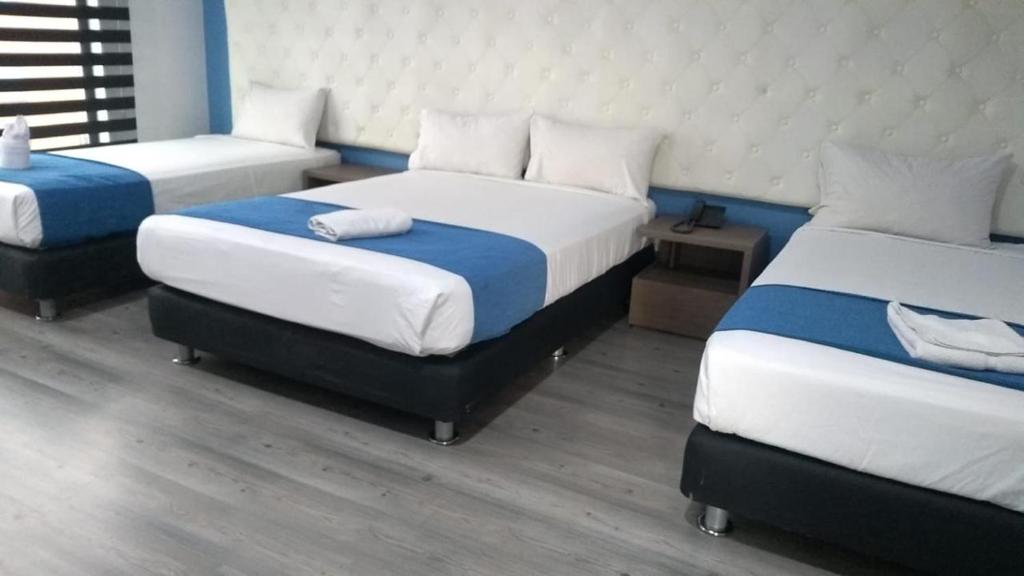 波哥大Plaza Miranda的一间房间,有三张床