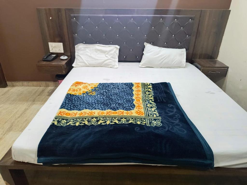 哈里瓦Galaxy Inn Hotel的床上有蓝色和橙色的毯子