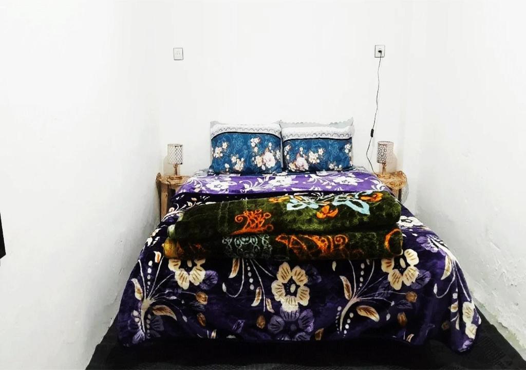 萨菲1A private room in a shared house for surfers的一间卧室配有一张带彩色毯子的床