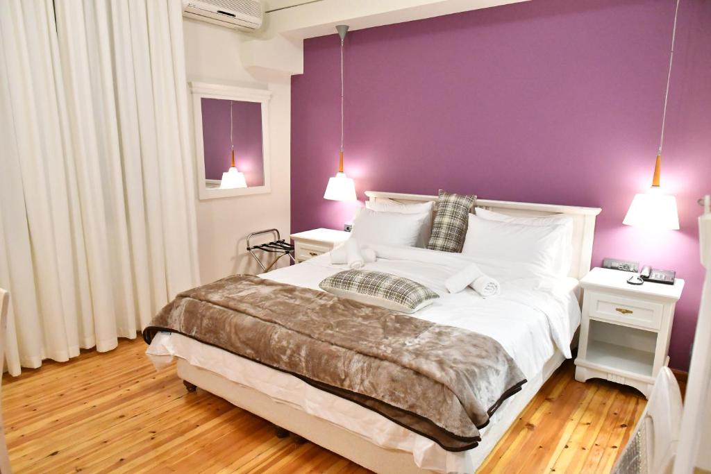 纳夫普利翁Porto Nafplio的一间卧室配有一张大床和紫色墙壁
