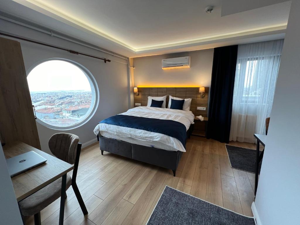 伊斯坦布尔The Blue Suites的一间卧室配有一张床、一张书桌和一个窗户。