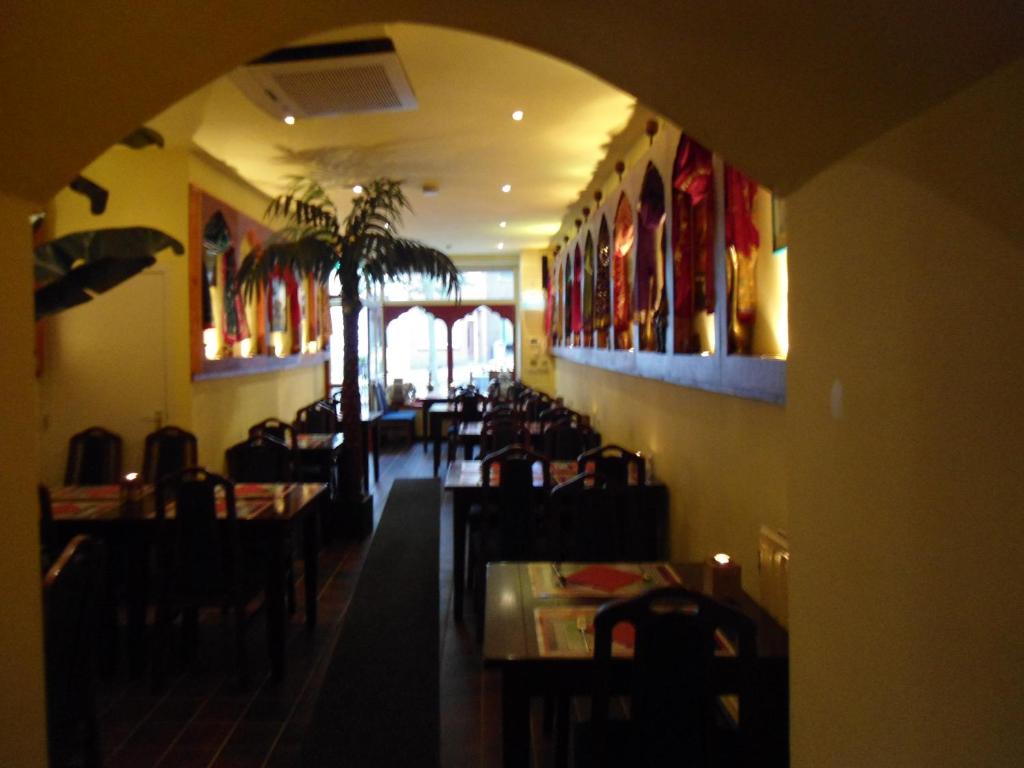 锡塔德SIMLA INDIAAS RESTAURANT VOOR KAMER的餐厅设有1间带桌椅的用餐室