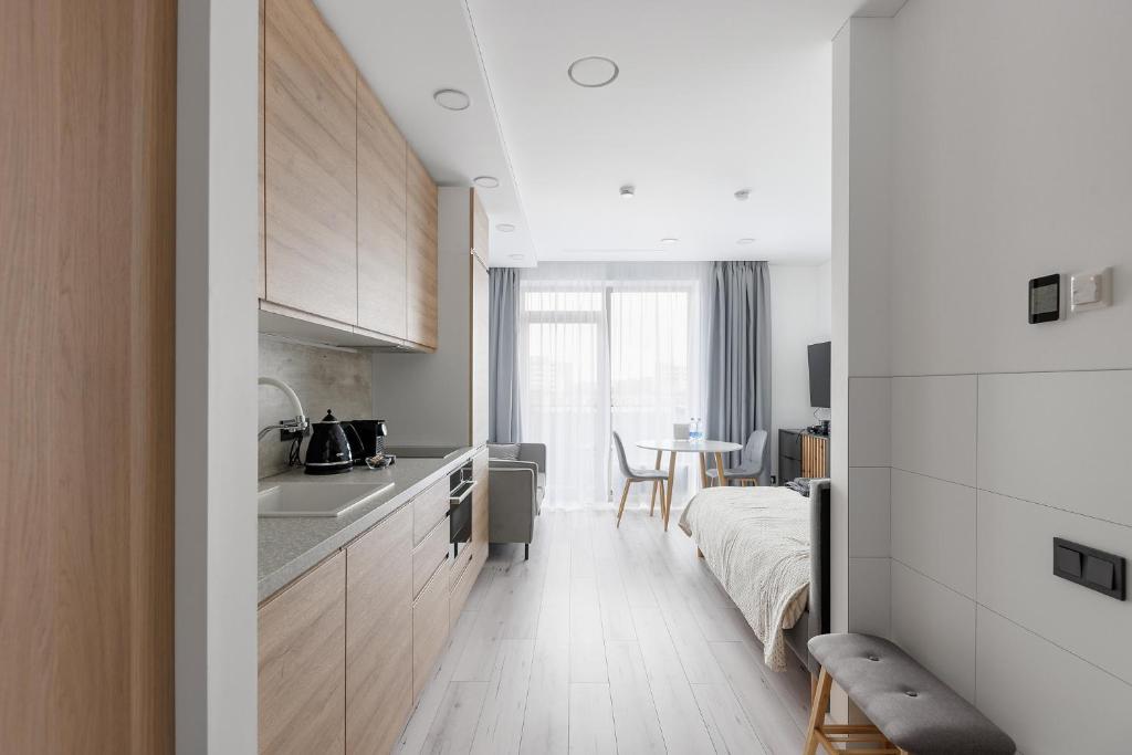 维尔纽斯Ozo eco apartments 5的一个带水槽的厨房和一张位于客房内的床