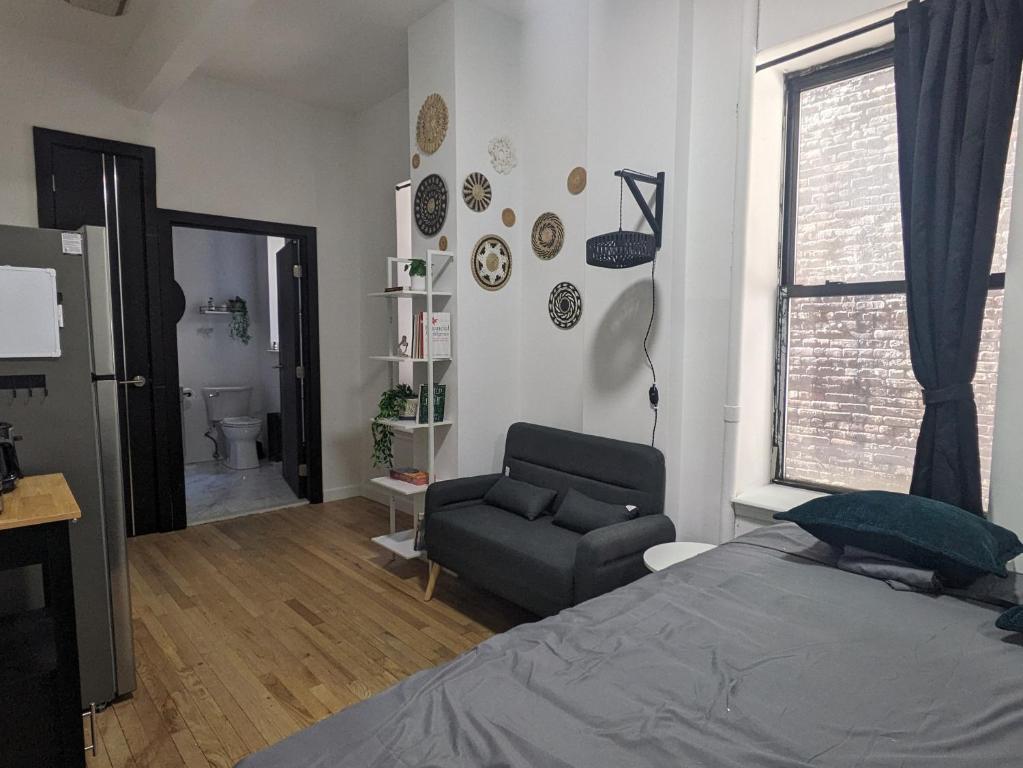 纽约Studio in Union Square的卧室配有床、椅子和窗户。