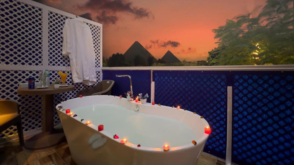 开罗Turquoise Pyramids & Grand Egyptian museum view Hotel的浴室配有带灯的浴缸。