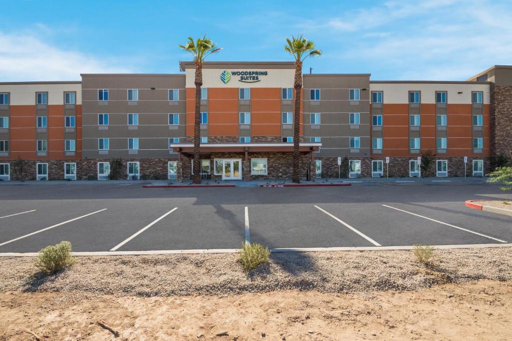 埃文代尔WoodSpring Suites Tolleson - Phoenix West的酒店前面的一个空停车位