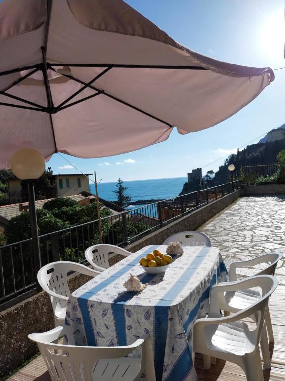 蒙特罗索阿尔马雷Fulvia's cozy apartment with terrace的一张桌子,上面放着一碗水果和一把雨伞