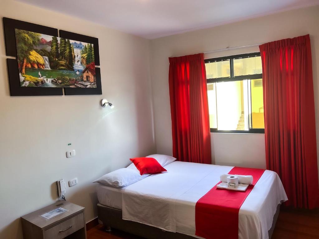 塔拉波托Residencial Marina House的一间卧室配有床和红色窗帘的窗户
